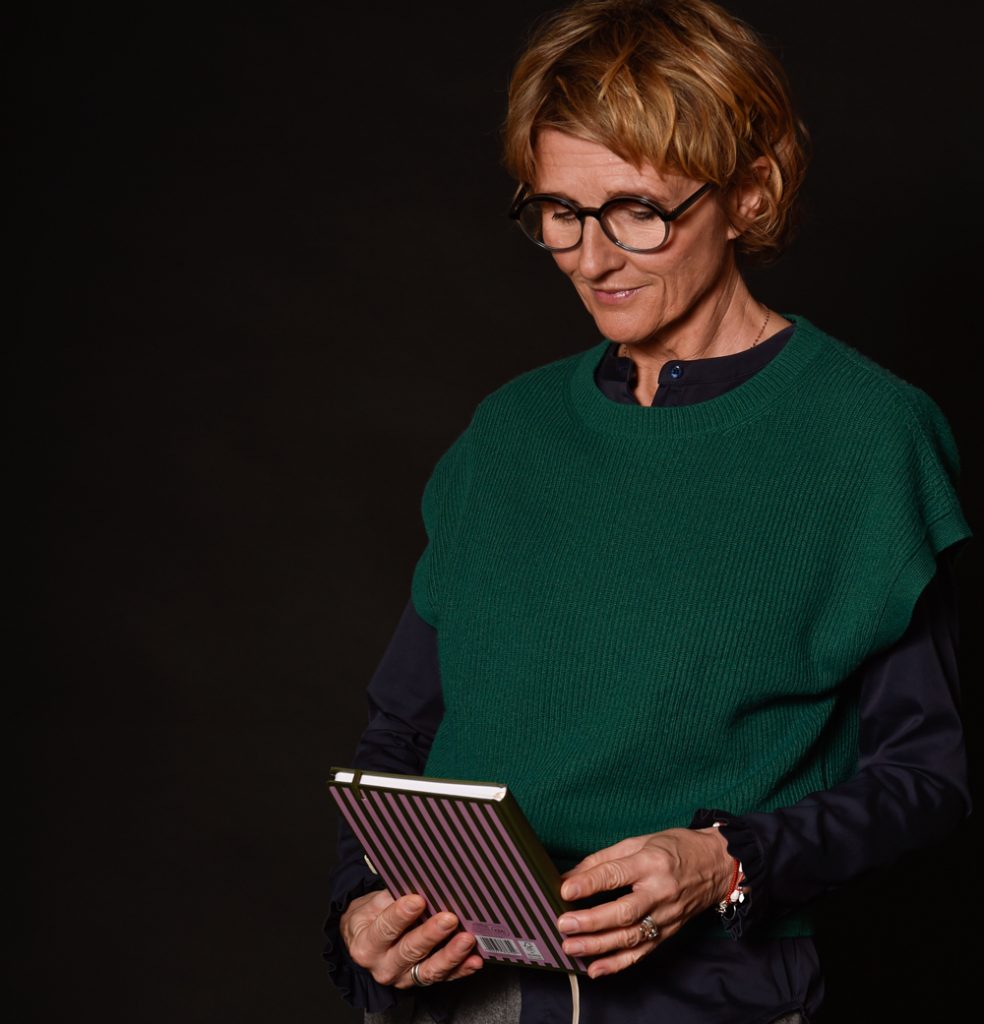 Susanne hält ein Buch in der Hand